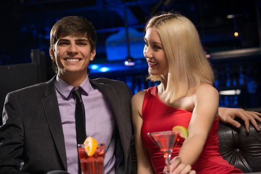 Young couple talking in a nightclub, have fun