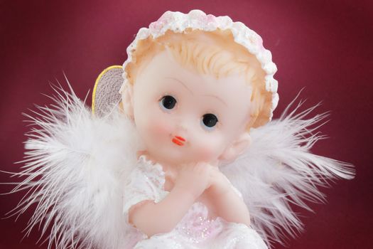 White angel in the guise of child against the dark background