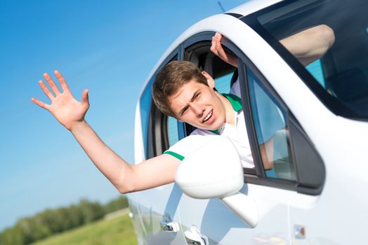 young man stuck his hand out of the window of the car, country car trip