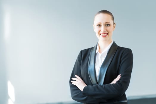 young modern business woman, crossed her arms and smiles