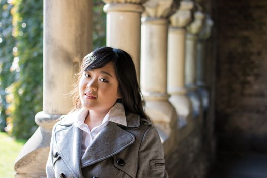 Young Asian woman standing near pillar structure