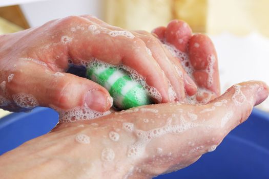 Man washes hands by the green soap