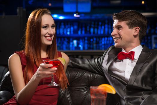 Young couple talking in a nightclub, have fun