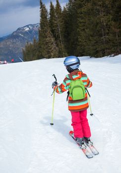 Girl on skis in soft snow in the mountains