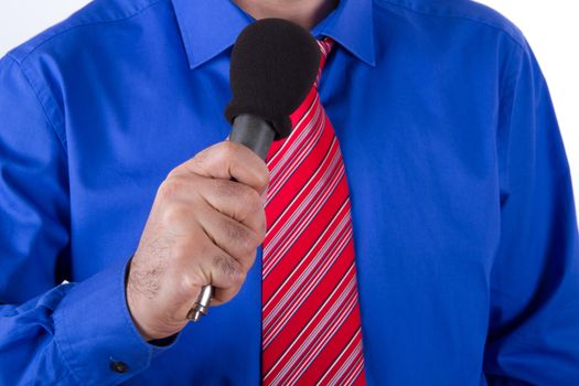 Businessman with red tie and blue shirt singing or speaking by microphone, isolated on white background.