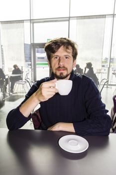 Young man drinking coffeein a cafe