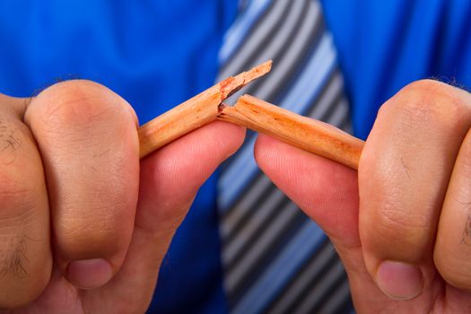 Businessman hand breaking yellow pencil.