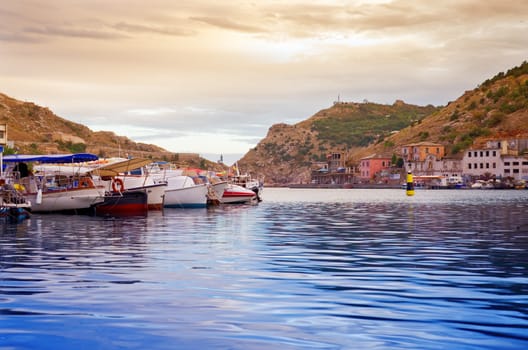 Boats moored in the bay at sunset