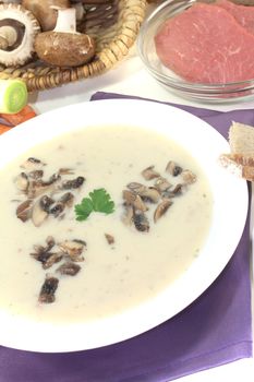 delicious Veal cream soup with mushrooms and parsley on a light background