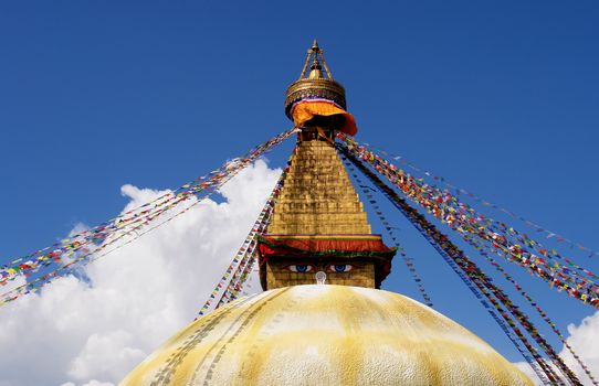 bodhnath stupa in kathmandu with buddha eyes and prayer flags on clear blue sky background