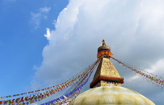 bodhnath stupa in kathmandu with buddha eyes and prayer flags on clear blue sky background