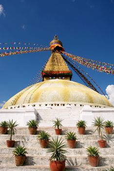 bodhnath stupa in kathmandu with buddha eyes and prayer flags on clear blue sky background