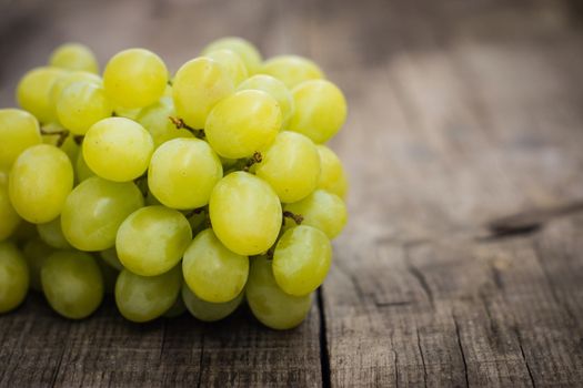 Fresh Green grapes on wood textured background. 