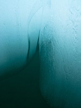 Abstract detail of submerged ice of iceberg drifting in deep blue water