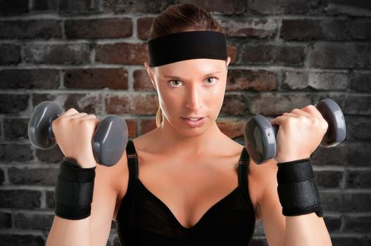 Woman working out with dumbbells at a gym