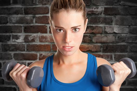 Woman working out with dumbbells at a gym