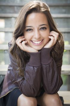 Portrait of a Pretty Mixed Race Young Adult Woman Sitting on a Staircase Wearing Leather Boots and Jacket.