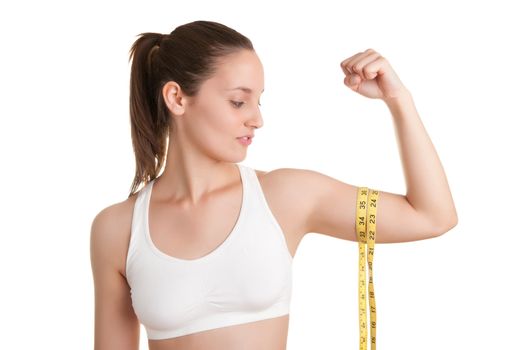 Powerful woman measuring her biceps with a yellow measuring tape