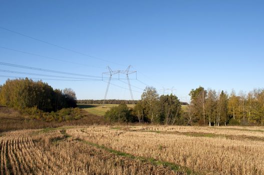 The high-voltage line running through the woods and fields