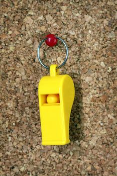 Yellow plastic whistle attached to the message board