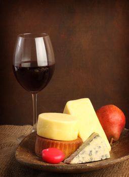 several kinds of cheese and a glass of red wine