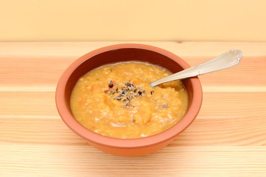 Bowl of hearty lentil and vegetable soup with extra seasoning