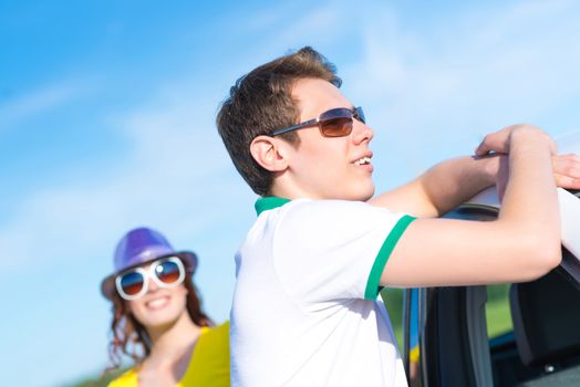 young man in sunglasses standing next to the car, the summer road trip