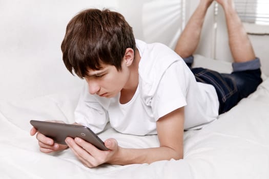 Sad Young Man with Tablet Computer on the bed