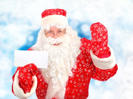 Santa Claus showing Blank Paper on the Abstract Winter Background