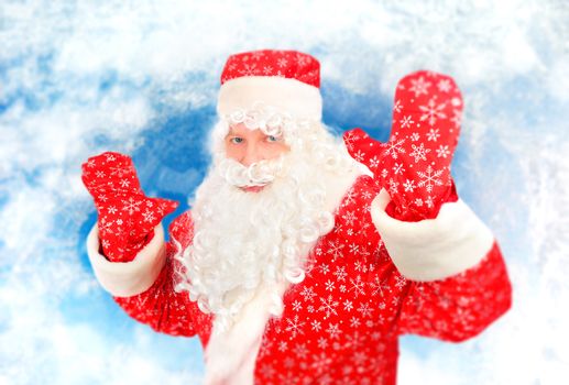 Cheerful Santa Claus with Hands Up on the Abstract Winter Background