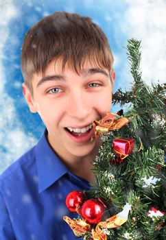 Happy Teenager with Christmas Tree on the Abstract Winter Background
