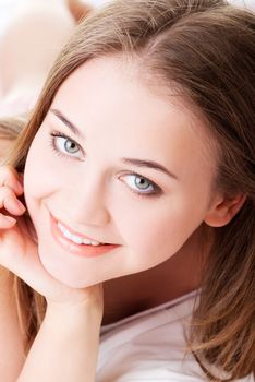 Attractive, young girl proping her bed.Lying in bed. Closeup. Portrait.