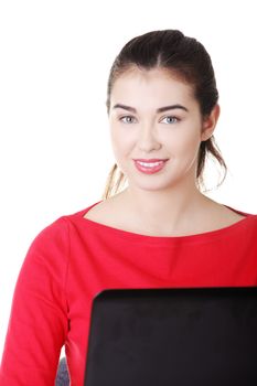 Happy casual woman sitting in front of computer. Isolated on white.