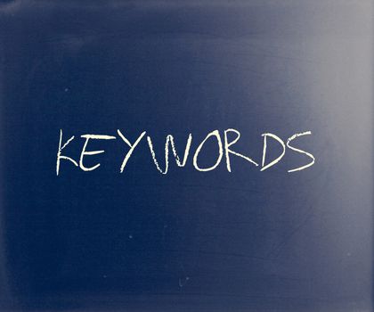"Keywords" handwritten with white chalk on a blackboard.