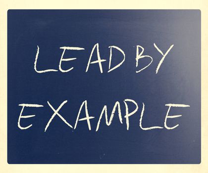 "Lead by example" handwritten with white chalk on a blackboard.