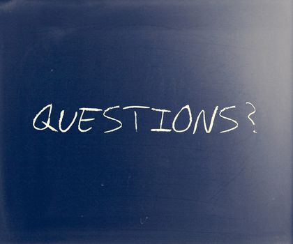 "Questions?" handwritten with white chalk on a blackboard.