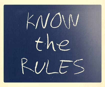"Know the rules" handwritten with white chalk on a blackboard.