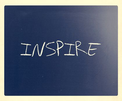 "Inspire" handwritten with white chalk on a blackboard.