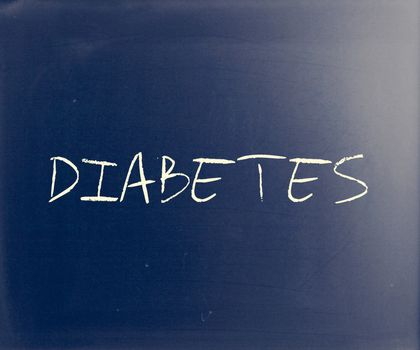 "Diabetes" handwritten with white chalk on a blackboard.