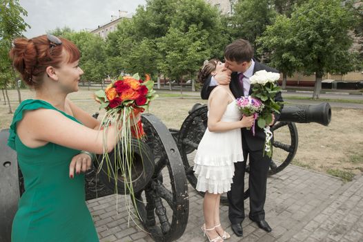 Moscow, Russia - July 10 2010. Traditional Russian weddind. The girlfriend of the bride looks as the groom and the bride make kiss.
