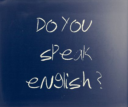 "Do you speak english" handwritten with white chalk on a blackboard.