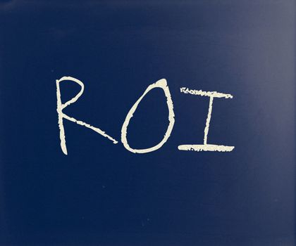 "ROI" handwritten with white chalk on a blackboard.