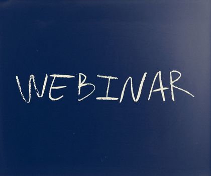 "Webinar" handwritten with white chalk on a blackboard.