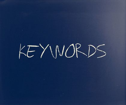 "Keywords" handwritten with white chalk on a blackboard.