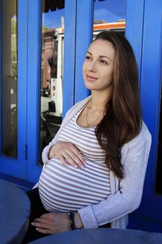 Beautiful pregnant woman in cafe