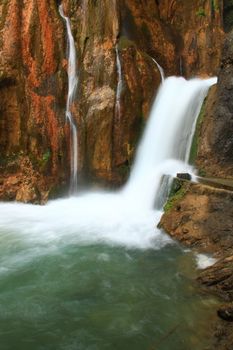 water falling to river between huge rocks 