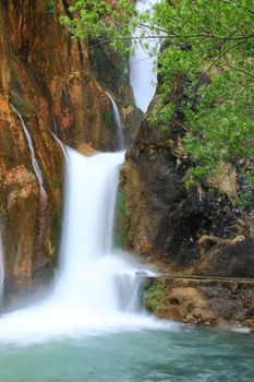 water falling to river between huge rocks 