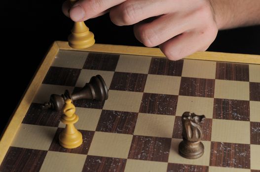 One Left Male Hand Playing Chess on a Black Background