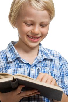 Close-up of a  cute young boy holding and reading a thick book. Isolated on white.