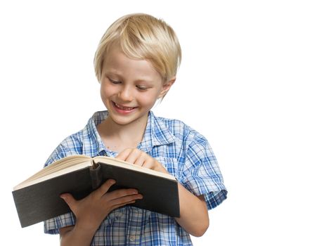 A happy young boy holding and reading a thick book. Isolated on white.
